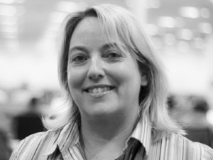 Photo of Sandra Flynn in black and white. The office background is blurred by the photographer..